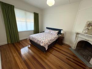 a bedroom with a bed and a fireplace at The Nook on the Hill in Armidale