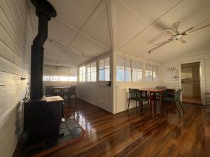 a room with a fireplace and a table and chairs at The Nook on the Hill in Armidale