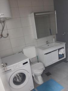 een badkamer met een wasmachine en een wastafel bij Fushkosov in Kosovo Polje