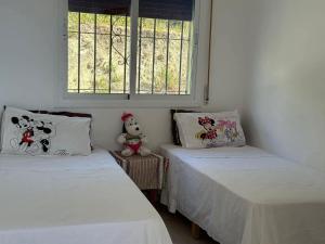 Dos camas individuales en una habitación con ventana. en Mini Villa Belyounech, en Belyounech 