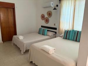 a room with two beds with towels on them at Hotel Quiloma Ranch in Palenque