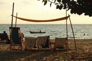a group of chairs and a boat on the beach at Dos Aguas Lodge in Rincón +54 photos