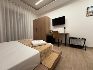 a bedroom with a bed and a desk and a television at Domus Matronae in Castellammare di Stabia +25 photos