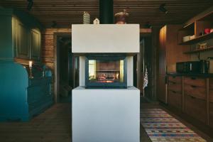 a living room with a fireplace in a kitchen at Lillstugan in Åre