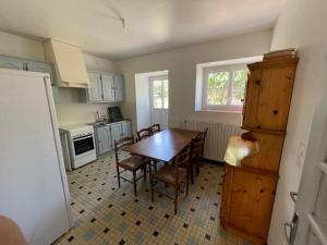 una cucina con tavolo e sedie in una cucina di Gite proche Chateau-gontier a Marigné-Peuton