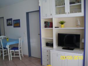 ein Wohnzimmer mit einem TV und einem Esstisch in der Unterkunft Apartmentanlage "Am Salzhaff" in Rerik