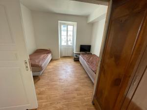 una piccola stanza con due letti e una televisione di Gite proche Chateau-gontier a Marigné-Peuton