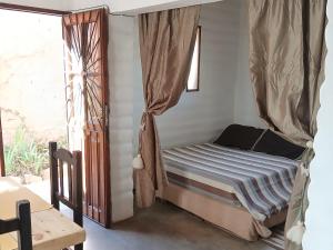 a bed with a canopy in a room with a window at Pacha Wasi in Humahuaca