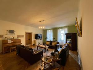 a living room with two couches and a piano at Casa Crown in Sighişoara