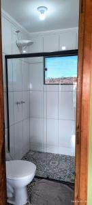 a bathroom with a toilet and a glass shower at Chalé estrela do cruzeiro in São Thomé das Letras