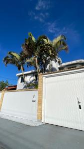 une porte de garage blanche avec un palmier derrière dans l'établissement Apartamento próximo ao Aeroporto de Florianópolis, à Florianópolis 20 autres photos