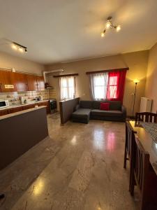 a living room with a couch and a kitchen at Authentic Village Stay in Kondodhespótion