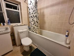 a bathroom with a toilet and a tub and a sink at Budget Room Stevenage Town Centre in Stevenage