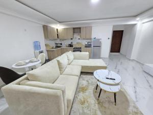 a living room with a couch and a table at Lorenas Tuffoam mall Apartment in Kisumu