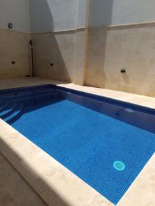 a large blue swimming pool in a room at Boscolo Flats Nadur - Modern Rooms with private en-suite bathrooms in Nadur