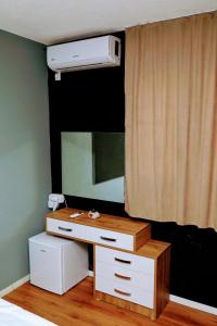 um quarto com uma cómoda com um espelho e uma cama em Hotel Ari em Prizren mais 49 fotografias