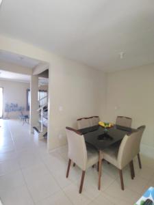 a dining room with a black table and chairs at Casa INDEPENDENTE 4 QUARTOS VILA DO PERÓ CABO FRIO in Cabo Frio