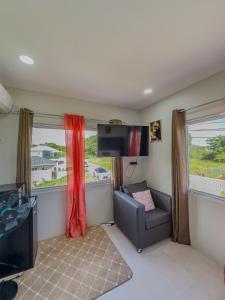 a living room with a couch and a tv at Two Bedroom Suite - 12min from UVF Airport in Vieux Fort +13 photos