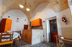 オーリアにあるcasa vacanze Filomenaのアーチ型の天井、テーブルと椅子付きのキッチン