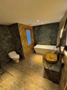 a bathroom with a tub and a toilet and a sink at Skarchan Resort Skardu in Skardu +35 photos
