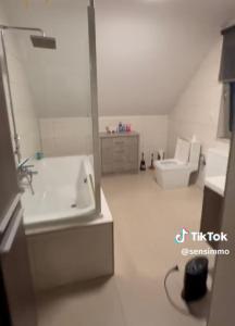 a bathroom with a sink and a tub and a toilet at Duplex appartement met 3 slaapkamers in Genk
