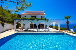 a villa with a swimming pool in front of a house at Panorama Villa in Pomos