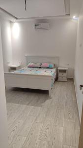 a bedroom with a bed and a wooden floor at Villa Hiba in Stehat +8 photos
