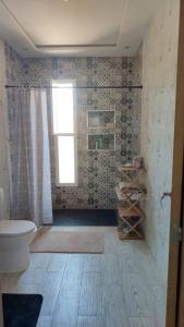 a bathroom with a toilet and a shower and a window at Villa Hiba in Stehat