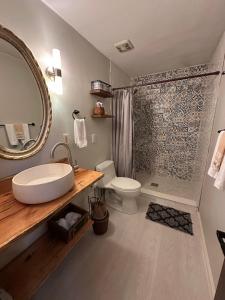 a bathroom with a sink and a toilet and a shower at Peaceful, cozy cabin in the woods in Murphy +27 photos