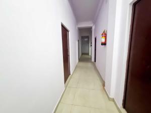 an empty hallway with white walls and a long corridor at OYO 90856 HOTEL MANNAT in Alīgarh