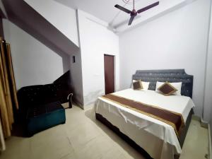 une chambre avec un lit et un ventilateur de plafond dans l'établissement OYO 90856 HOTEL MANNAT, à Aligarh