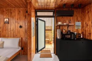 a bedroom with a bed and a door to a kitchen at Ghost House at Ghost Town Casitas in Terlingua
