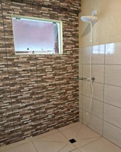 a bathroom with a glass shower with a window at Casa Vilarejo in Morretes