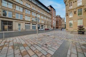 a cobblestone street in a city with tall buildings at Luxurious Royal 2BR Apartment, Glasgow City Centre in Glasgow