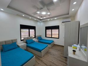 une chambre à l'hôpital avec deux lits et deux fenêtres dans l'établissement منتجع تل الربيع - Tal Al-Rabi Resort, à Ajloun