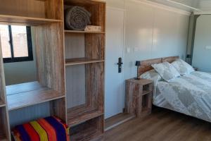a bedroom with a bed and a wooden book shelf at Luna de Chañares in San Pedro de Atacama