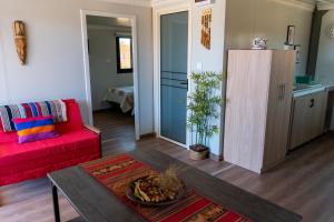 a living room with a red couch and a table at Luna de Chañares in San Pedro de Atacama