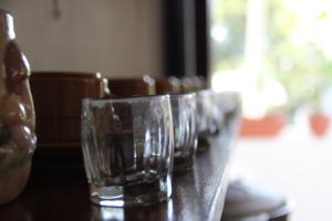 una fila de vasos vacíos sentados en una mesa en Hostal Mi Castillo en Mariabé