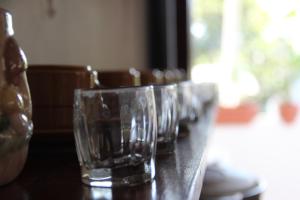 una fila de vasos vacíos sentados en una mesa en Hostal Mi Castillo, en Mariabé