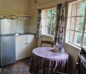 a small kitchen with a table and a refrigerator at Limerick cottages in Bulawayo +16 photos