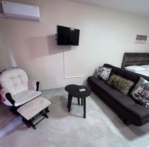 a living room with a couch and a chair at THE NEST Studio Apartment in Philipsburg