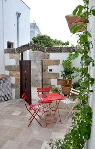 einen roten Stuhl und einen Tisch auf der Terrasse in der Unterkunft Rosa dei Venti in Tricase