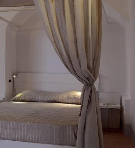 a bed with a curtain in a bedroom at Rosa dei Venti in Tricase