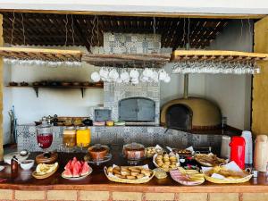 a table with plates of food on a counter in a kitchen at Hotel Fazenda Brisa dos Gerais in Palmeiras