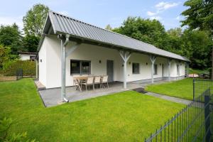 a white house with a table in a yard at Ferienhaus-Anton-Charlotte in Schwarz
