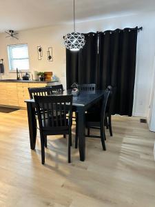 a black dining room table and chairs in a kitchen at Blessed Beyond Measure King with Ensuite in Norwalk +7 photos