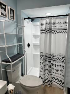 a bathroom with a toilet and a shower curtain at Blessed Beyond Measure King with Ensuite in Norwalk