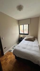 a bedroom with a white bed and a window at Habitación central Viña Centro, barrio Poniente in Viña del Mar +2 photos