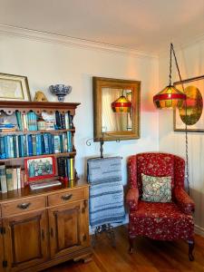 a room with a chair and a book shelf with books at The Lookout House at The Bluebird in Eureka Springs +65 photos