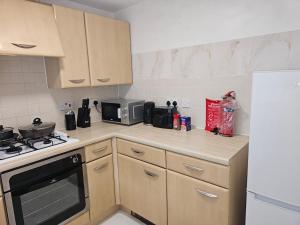 a kitchen with wooden cabinets and a stove top oven at Luton Homes in Luton